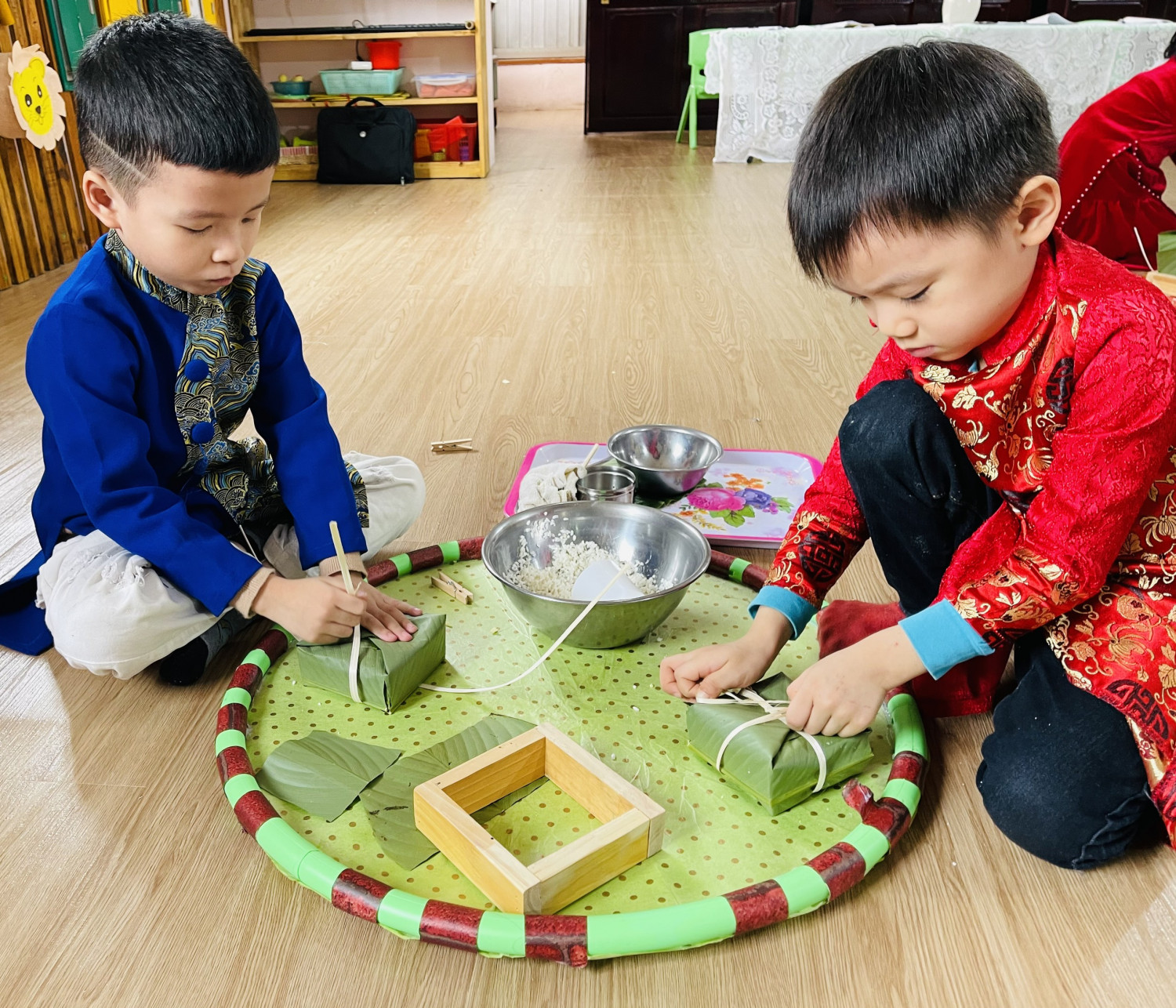 "Bánh trưng xanh bên dưa hấu đỏ. Cành mai vàng bên nhành đào tươi". Bé hào hứng với hoạt động trải nghiệm: Gói bánh trưng xanh. Lớp MGL 5-6 tuổi